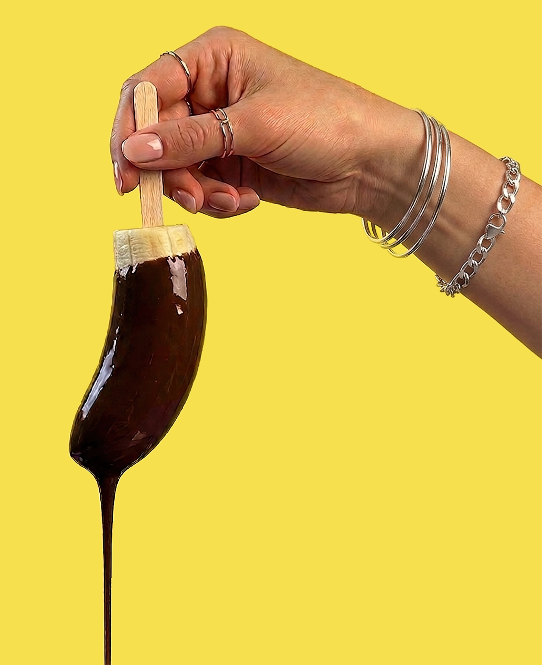 Hand holding a chocolate-dipped frozen banana